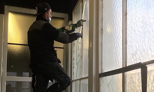 Zwei Handwerker bauen Fenster aus am Euskirchener Bahnhof. 
