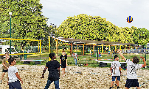 Jugendliche spielen Volleyball bei den Summer Games. 