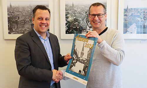 Bürgermeister Sacha Reichelt nimmt den Kalender vom z.eu.s.-Vorsitzenden Christian Lange entgegen.