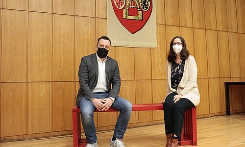 Bürgermeister Sacha Reichelt und Gleichstellungsbeauftragte Barbara Brieden auf der roten Bank