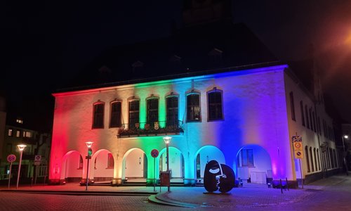 Das Alte Rathaus angeleuchtet in Regenbogenfarben.
