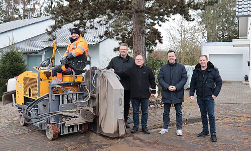 Vertreter von Stadt, Dorfgemeinschaft und Telekom mit der Maschine, die die Glasfaserkabel in Schweinheim einzieht.