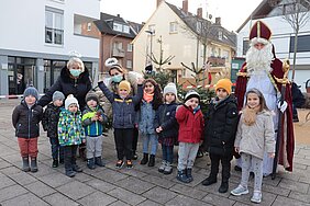 Kinder und Erwachsene stehen mit einem verkleideten Nikolaus auf dem Rüdesheimer Platz in Euskirchen.