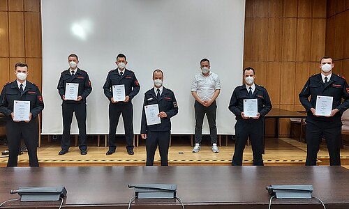 Bürgermeister Sacha Reichelt mit sechs Feuerwehrmännern bei der Urkundenübergabe