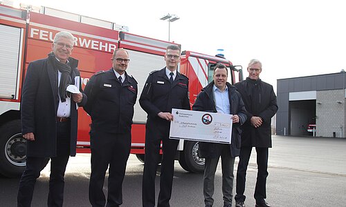 Vertreter der Stadt Euskirchen mit Feuerwehrleuten vor einem Feuerwehrfahrzeug an der Feuerwache in Euskirchen.