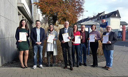 Euskirchens Bürgermeister mit den Heiratsstandesbeamten, die ihre Urkunden zeigen.