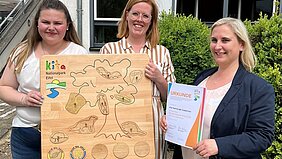 Kita-Leitung Iris Funk, Claudia Freisem und Denise Bruckmann präsentieren die Auszeichnung.
